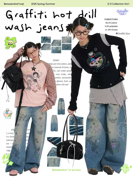 ラインストーンのディテールとウォッシュ仕上げが施されたブルーのグラフィティプリントジーンズ